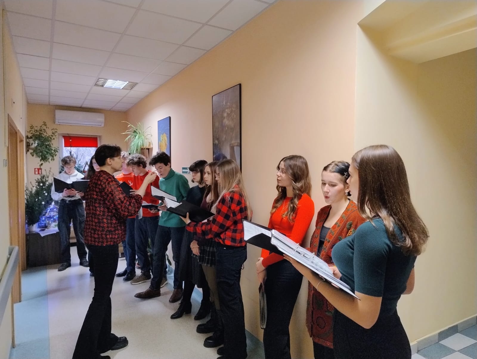 grupa kilku osób śpiewa na korytarzu Hospicjum